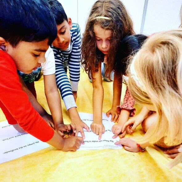 Sechs Kinder lesen einen englischen Text